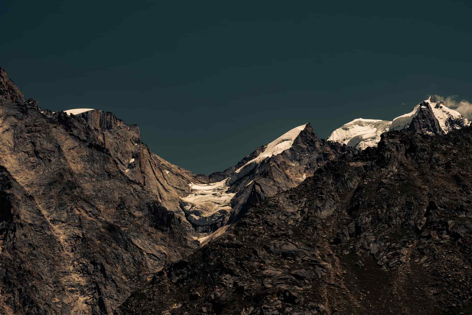 Dark mountains beneath a deep blue sky