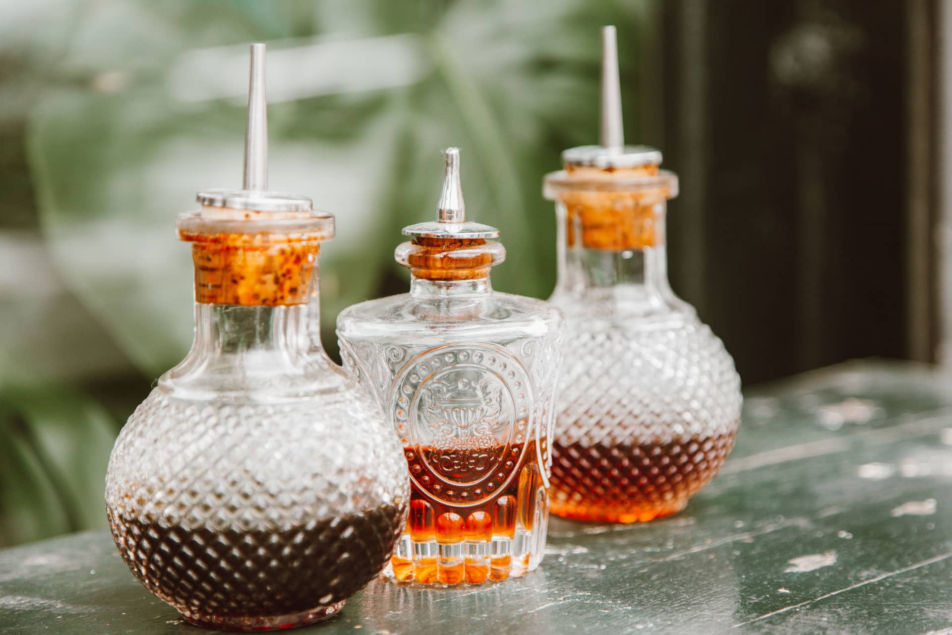 Glass condiment bottles and spices on a rustic table
