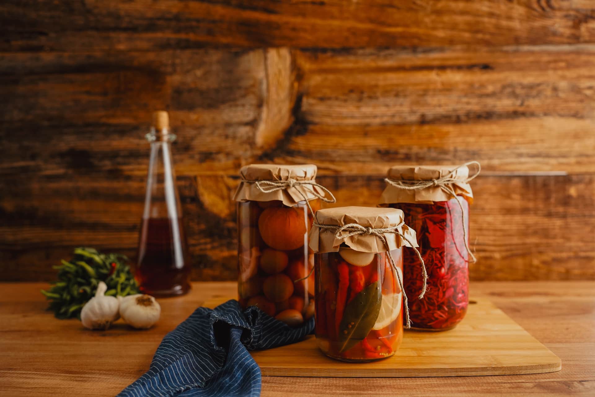Jars of preserved vegetables on a wooden surface