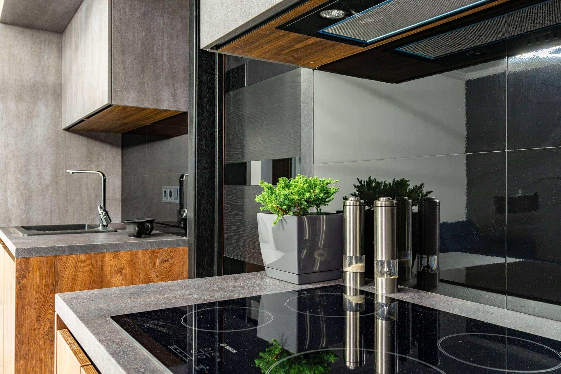A contemporary kitchen with an induction cooktop and stainless cookware