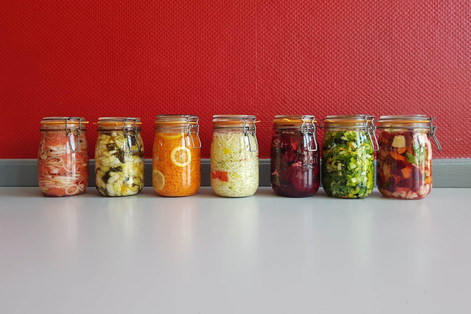 A row of multicolored jars filled with fermented vegetables