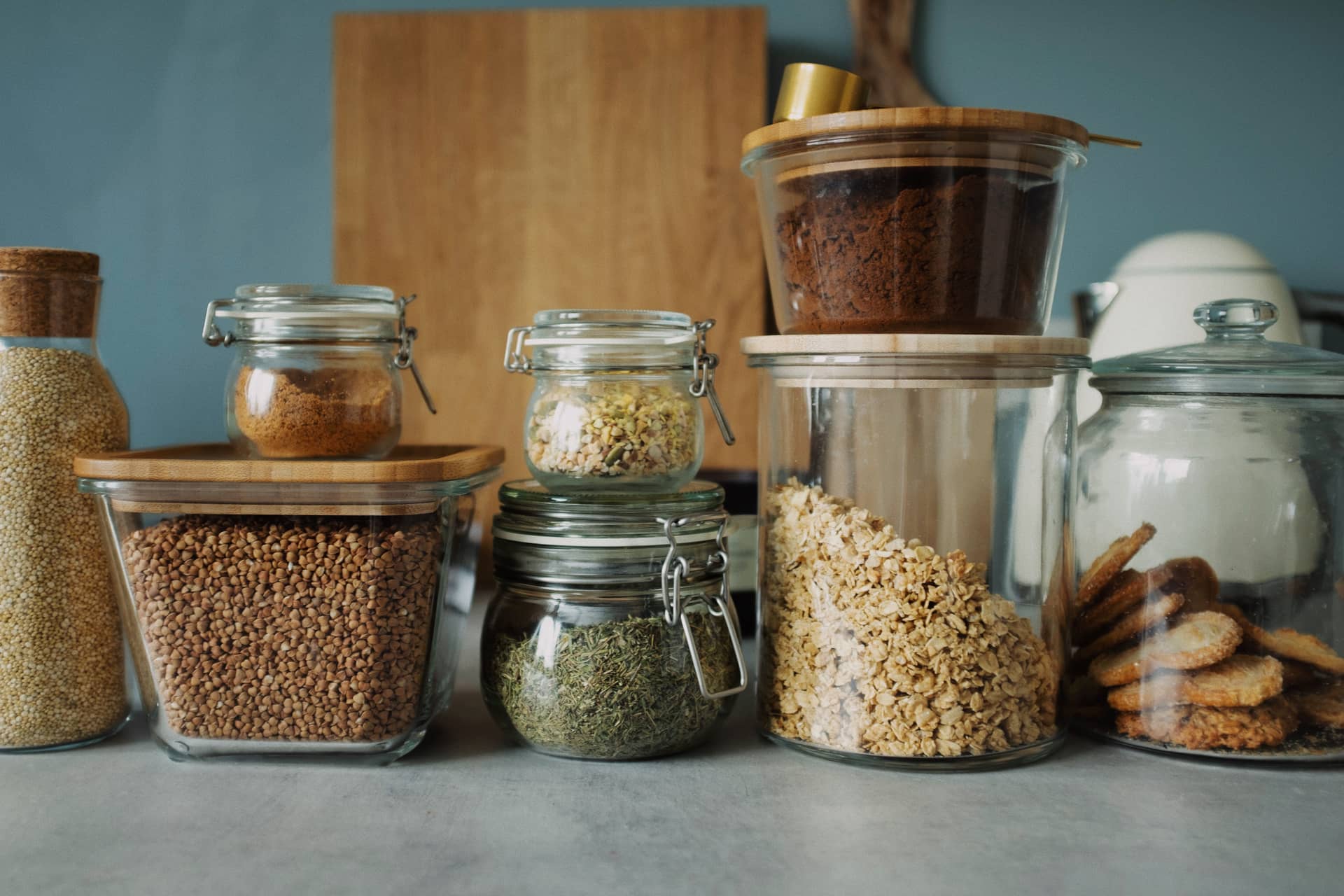 A pantry shelf of glass storage jars filled with dry goods