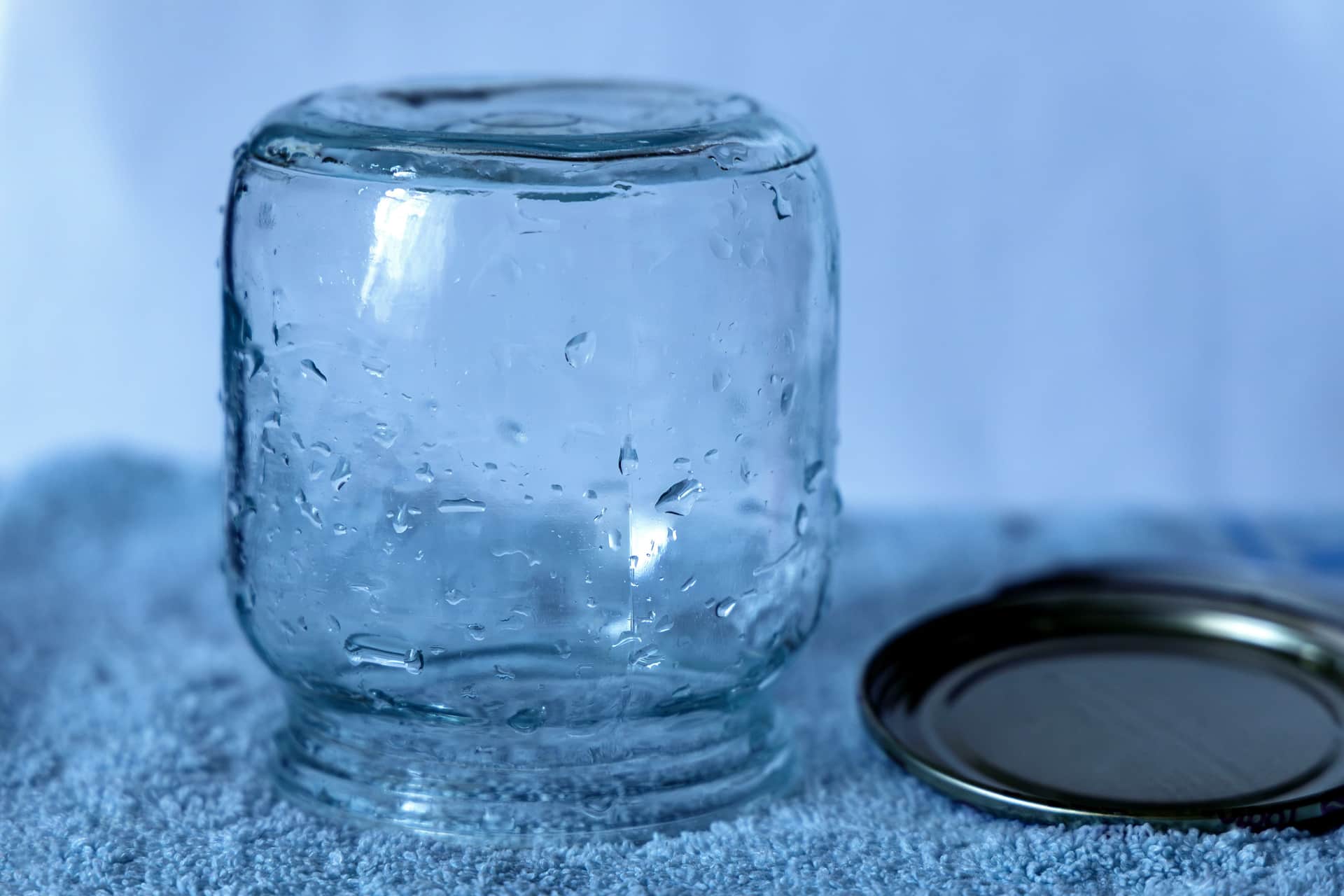 A glass jar with a metal lid resting on a textured cloth