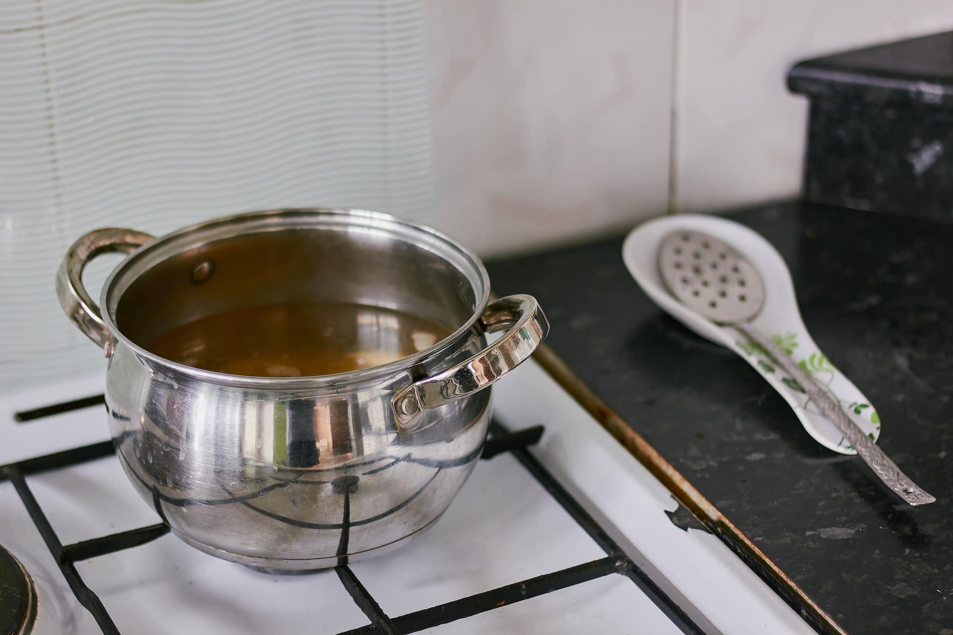 A large stainless steel pot on a kitchen stove