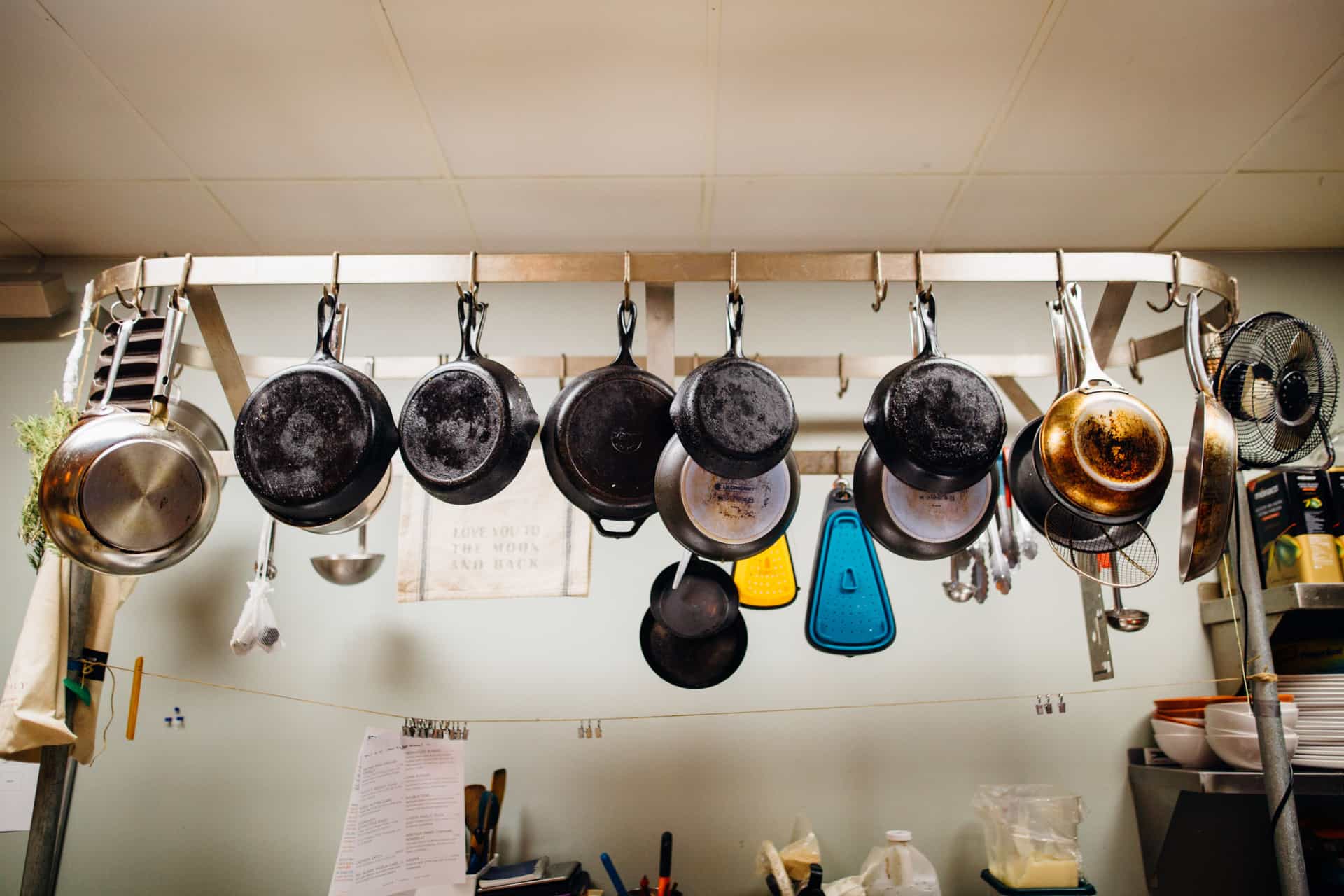 Assorted pans hanging on a kitchen pot rack